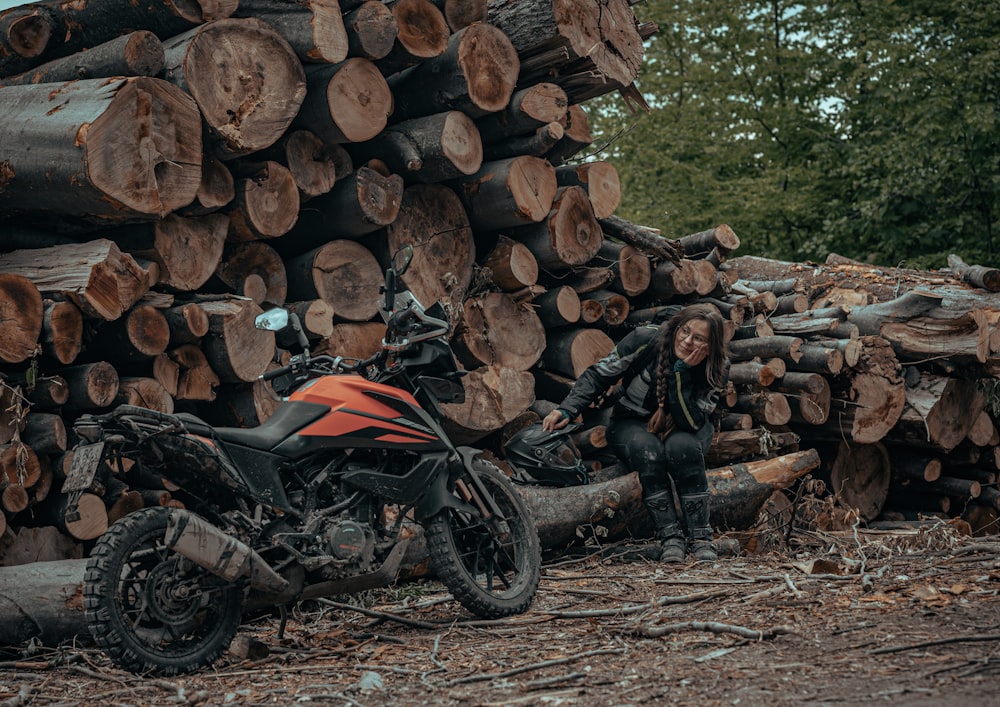 a motorcycle parked next to a pile of logs
