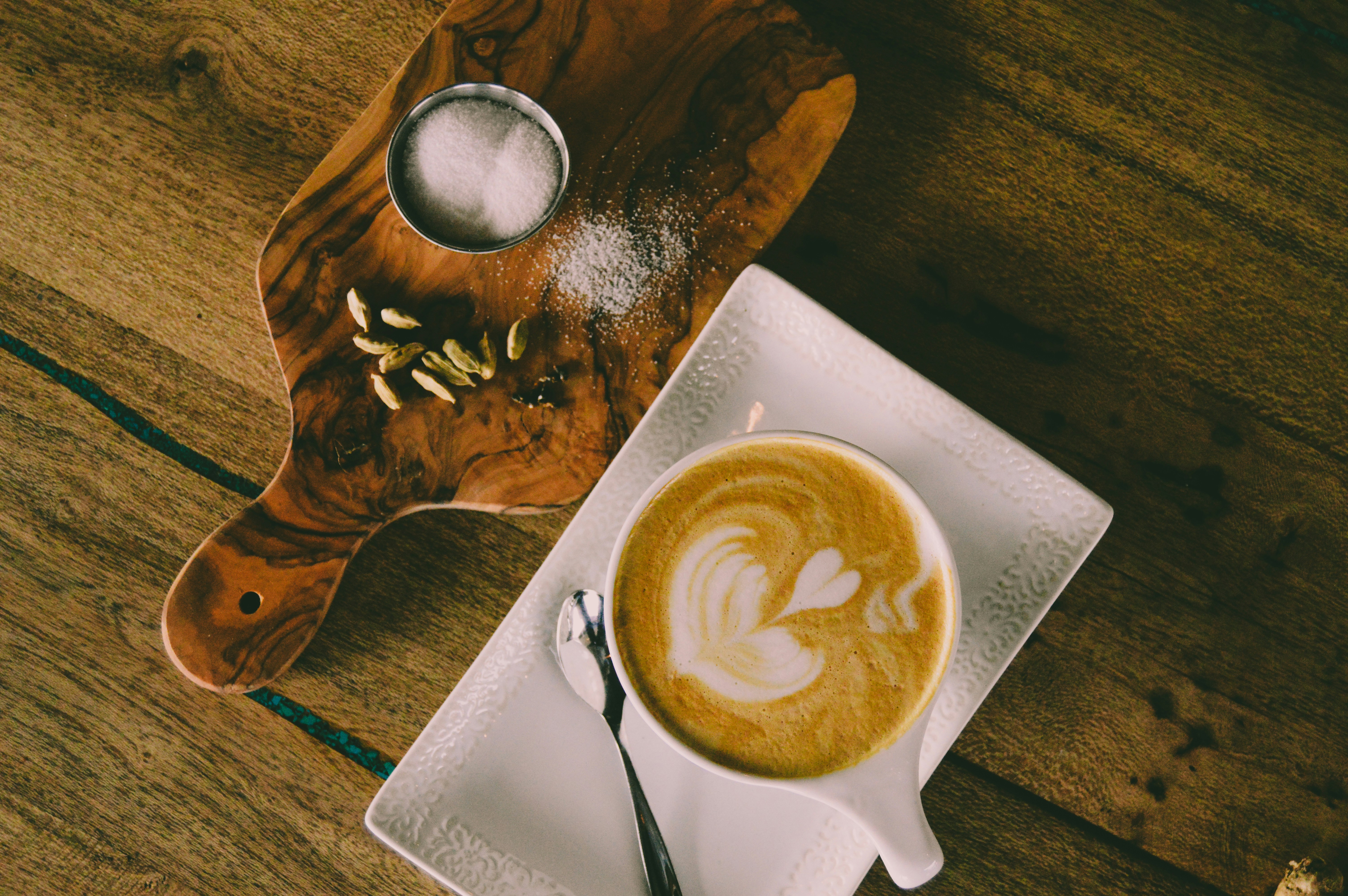 a cup of coffee on a plate with a spoon