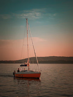 A couple enjoying a serene sunset cruise aboard a classic sailboat with polished wood finishes.