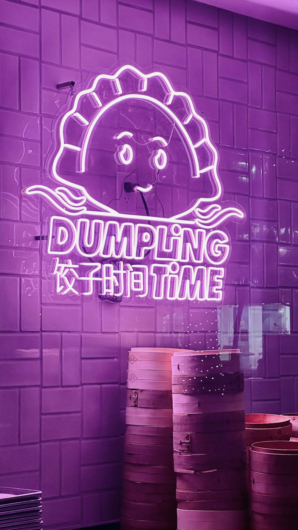 Una pared púrpura con un letrero de neón que dice dumpling x nighttime