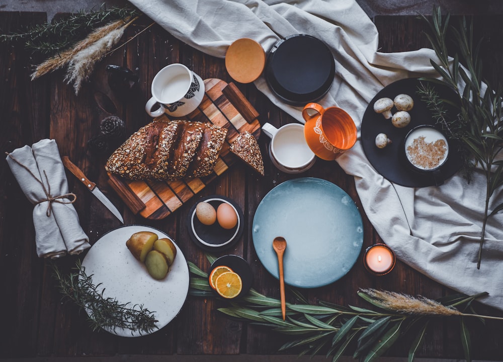 a wooden table topped with plates and bowls filled with food