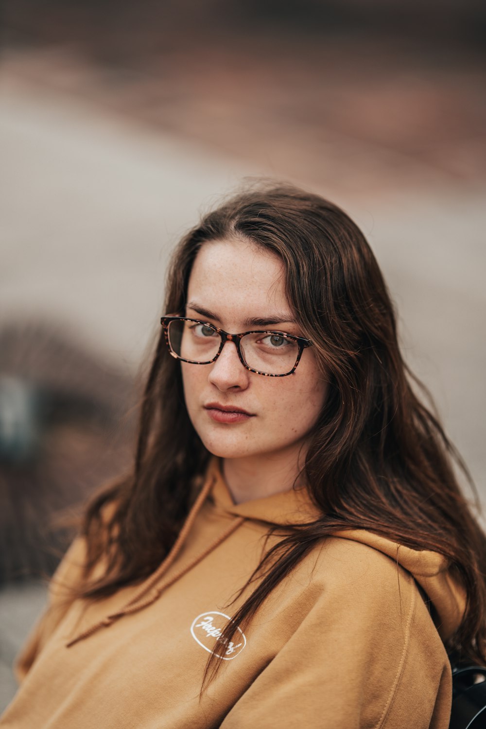 a woman wearing glasses and a hoodie