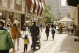 A neighborhood street with families walking and children playing.