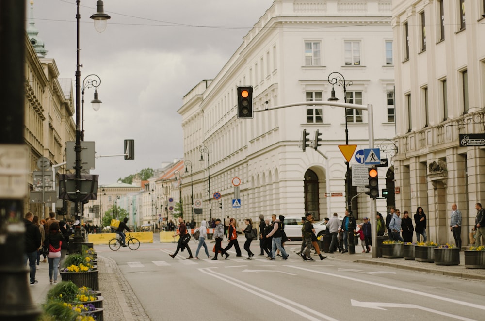 a group of people walking across a street