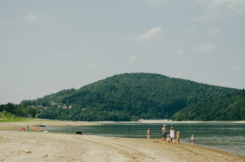 a group of people standing on top of a sandy beach