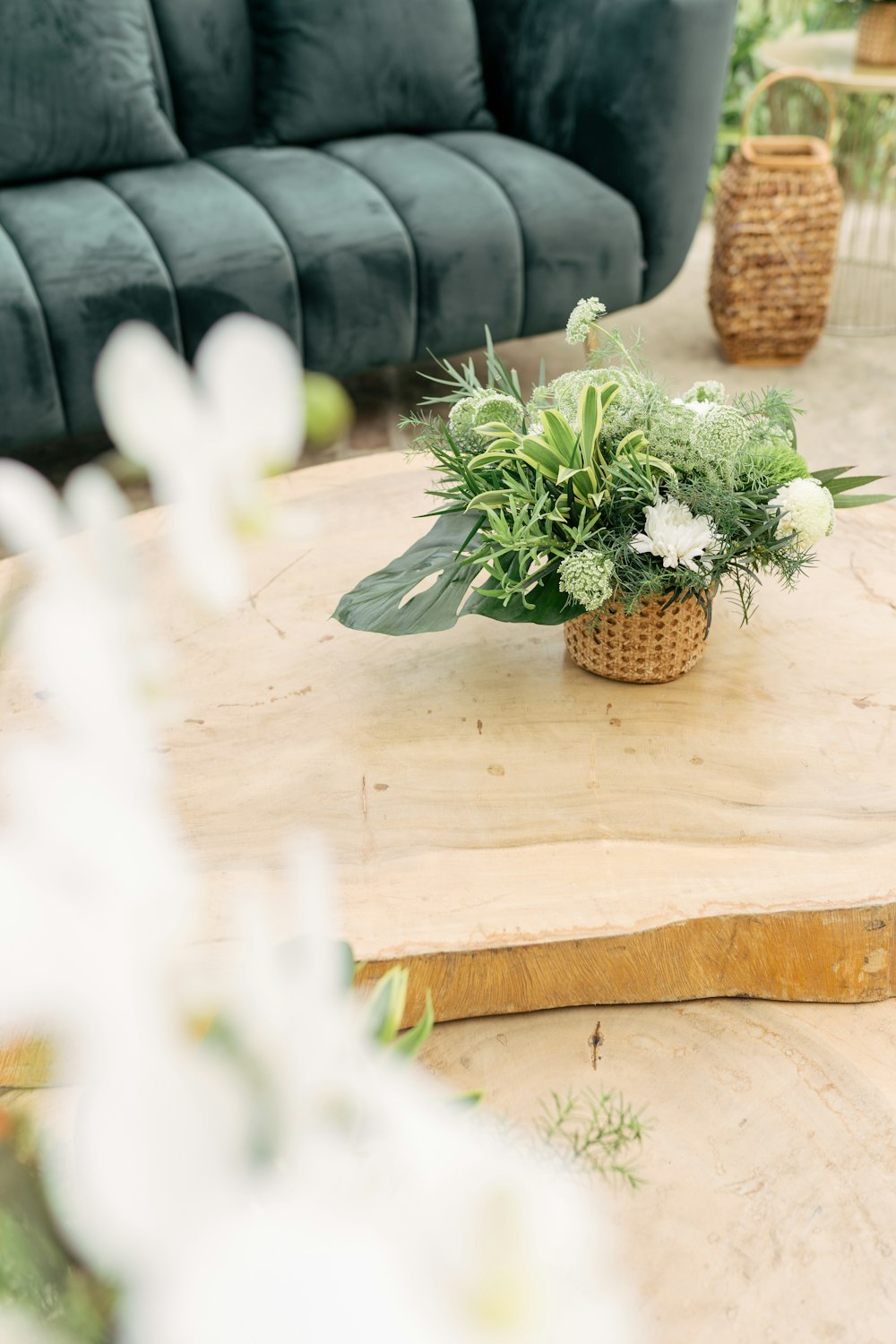 a wooden table topped with a basket filled with flowers