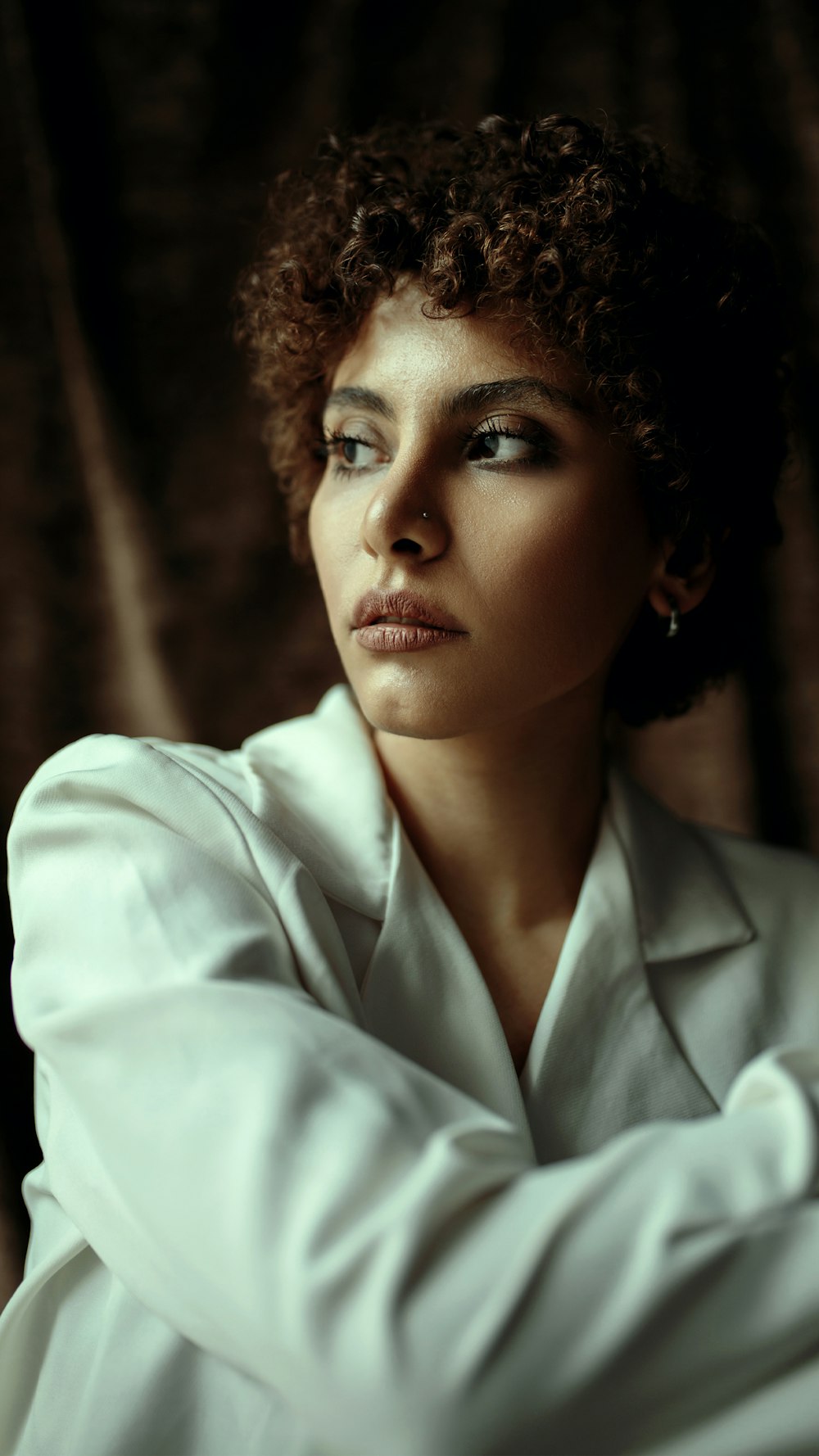 a woman with curly hair wearing a white shirt