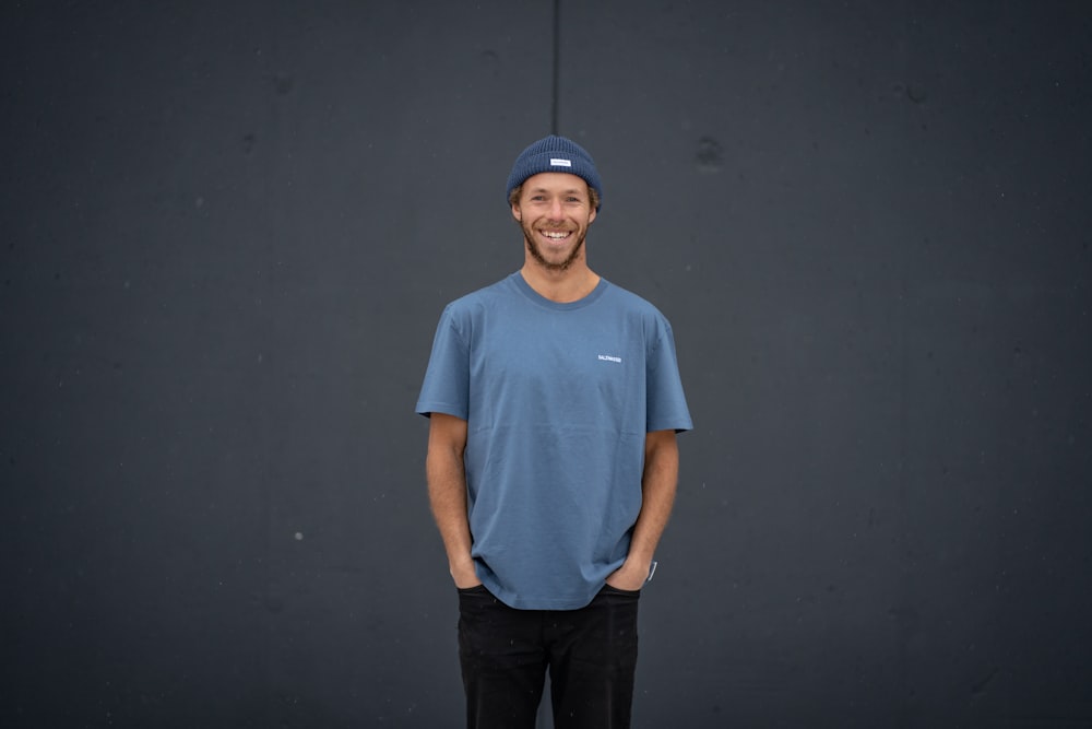 a man standing in front of a black wall