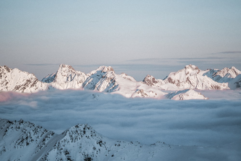 a group of mountains covered in snow under a blue sky