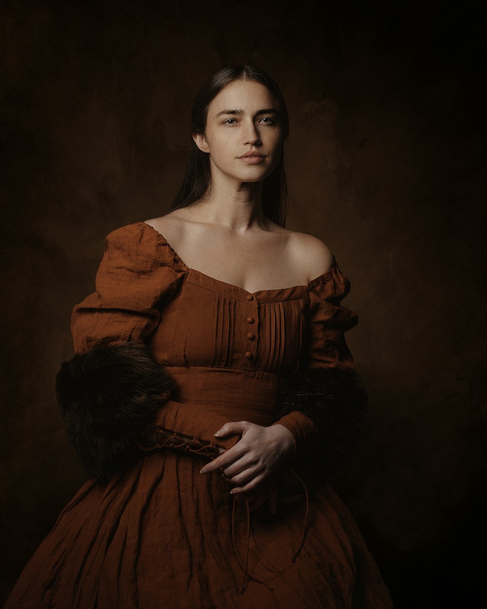 Eine Frau im braunen Kleid posiert für ein Foto