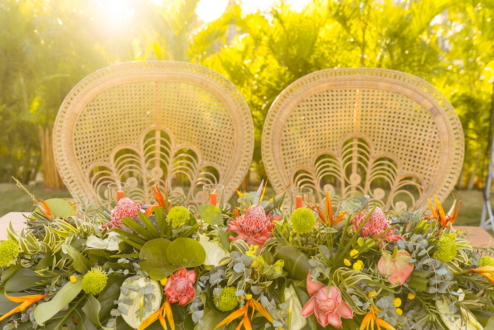 two wicker chairs sitting next to each other with flowers on them