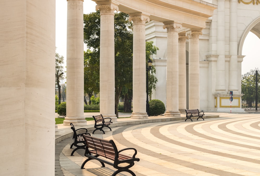 a row of benches sitting next to each other in a park