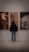 A person is standing in front of three abstract portraits displayed on a wall. The person is viewing the artworks closely, suggesting interest and engagement. The portraits each have distinct features, with the left one showing a face illuminated by a bright light, the center one having a blurred, warm-toned appearance, and the right one depicting a prominent eye.