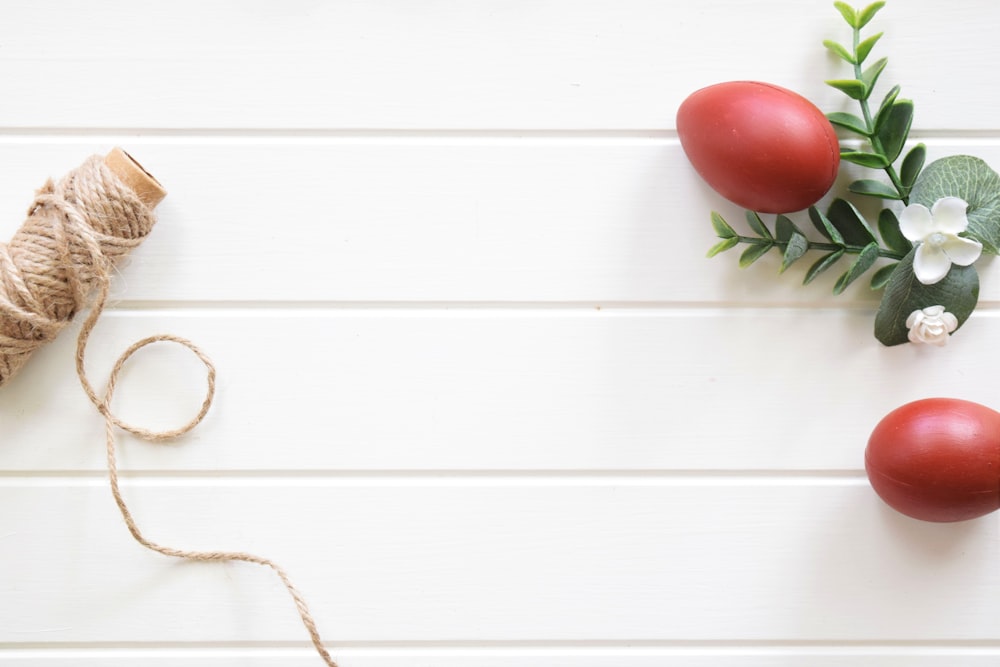 tomatoes and a spool of twine on a white background