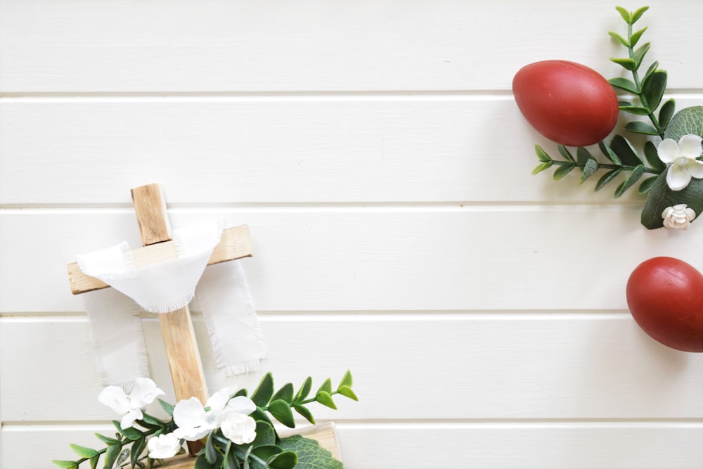 a cross with flowers and a t - shirt hanging on a wall