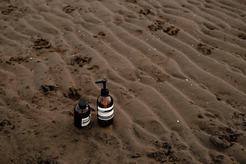 Botellas sobre la arena de la playa: protecci&oacute;n solar