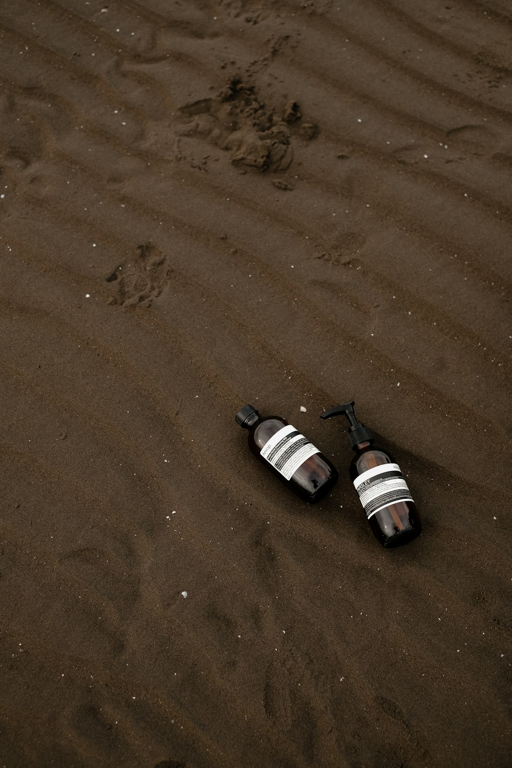a pair of slippers laying on top of a sandy beach