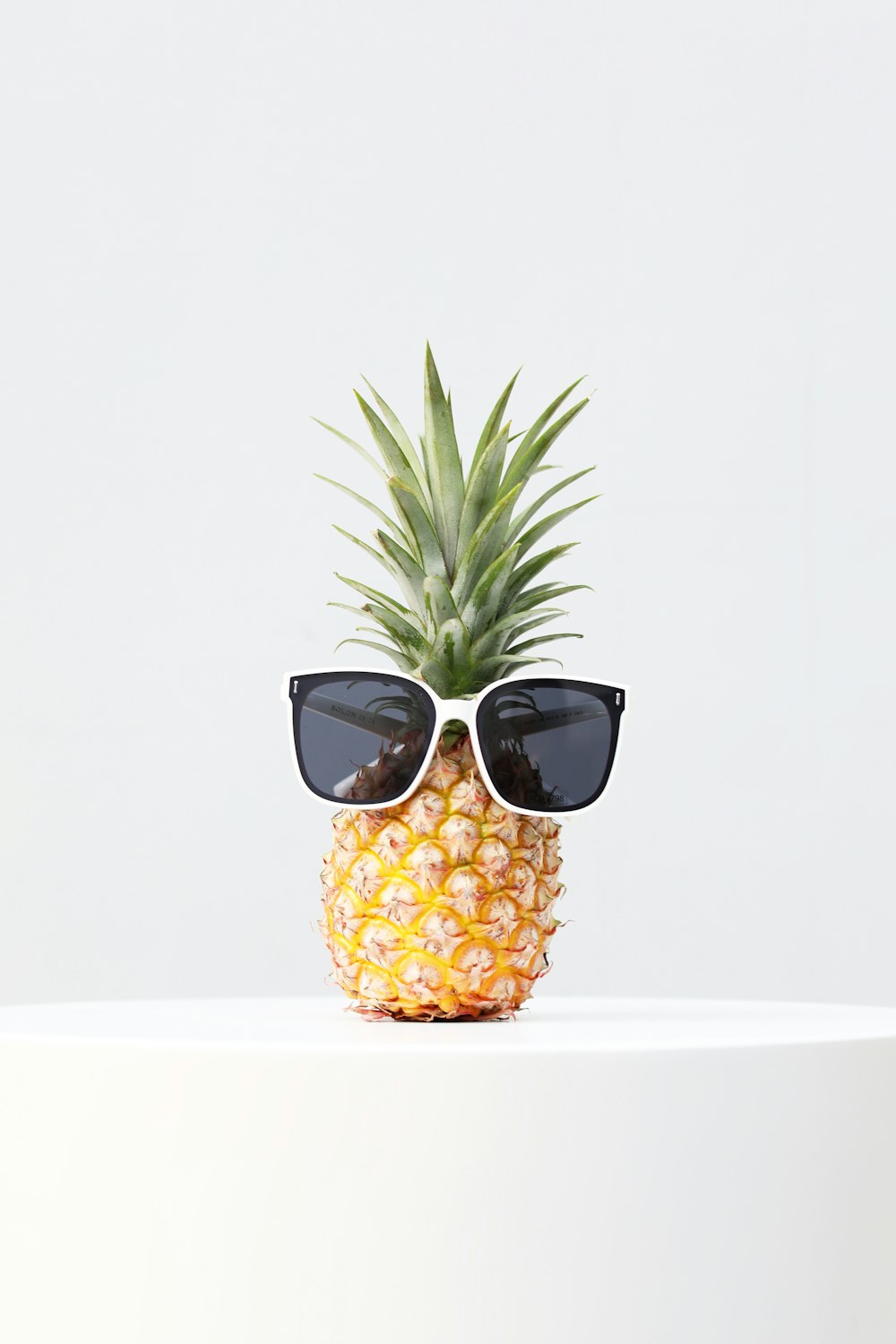 a pineapple wearing sunglasses sitting on top of a table