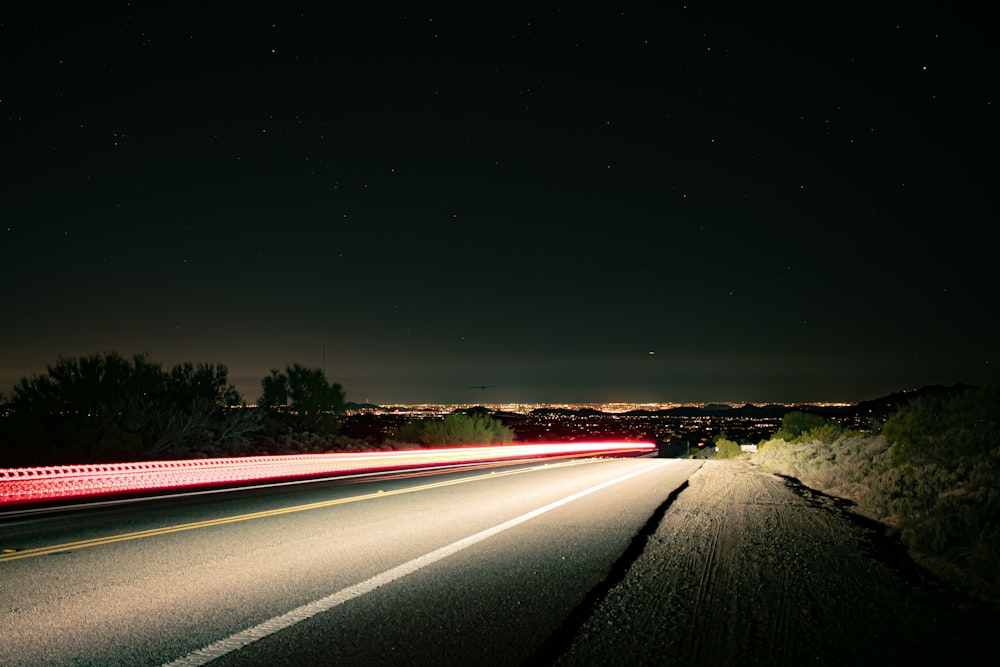 a long exposure photo of a highway at night