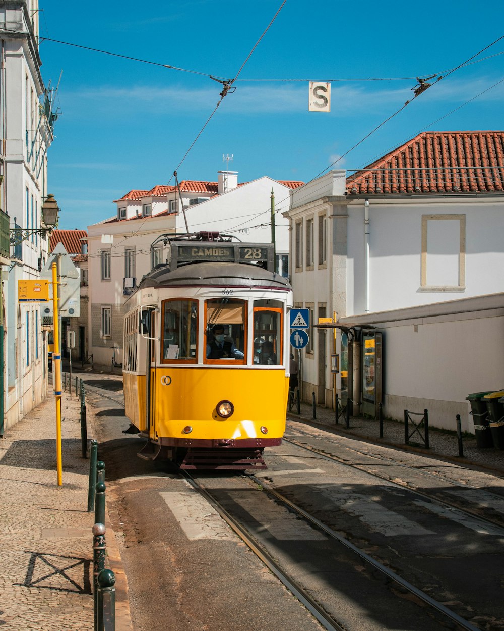 a yellow trolley is going down the tracks