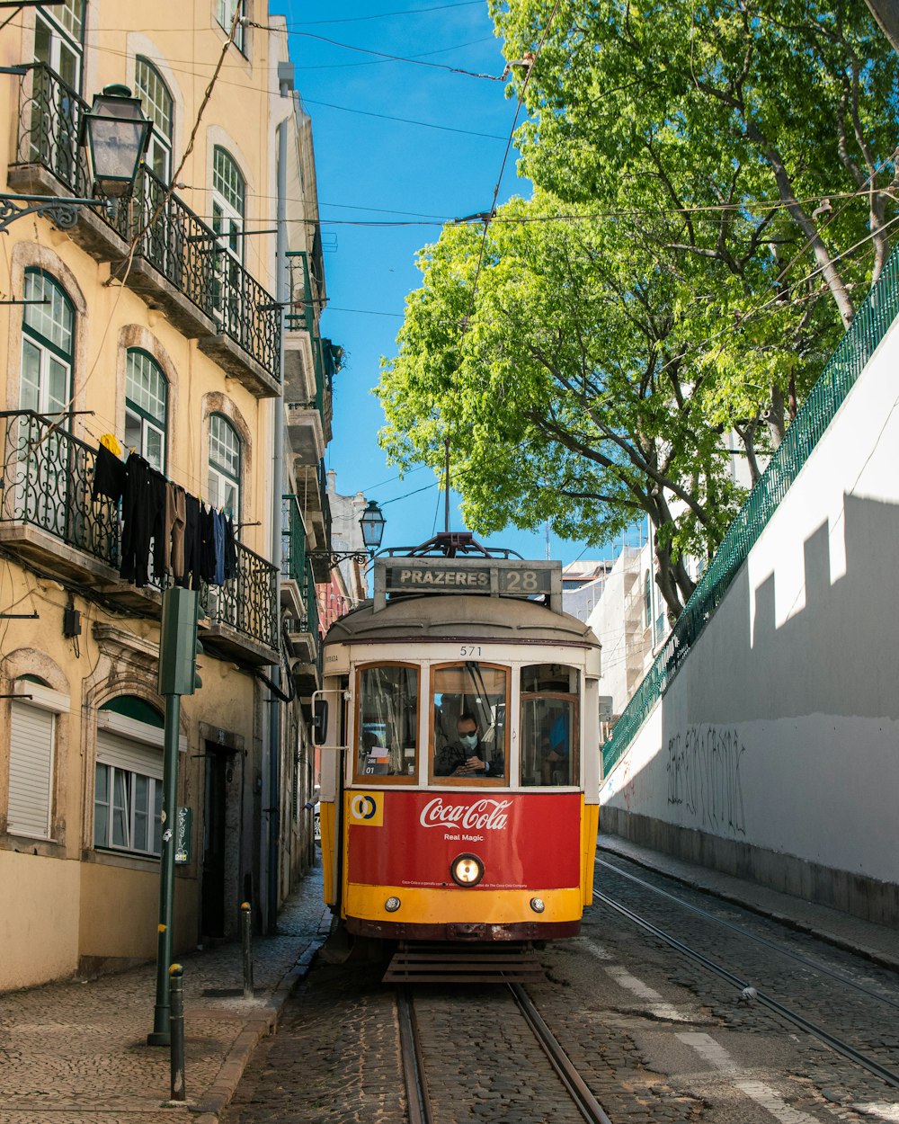 a red and yellow trolley car traveling down a street
