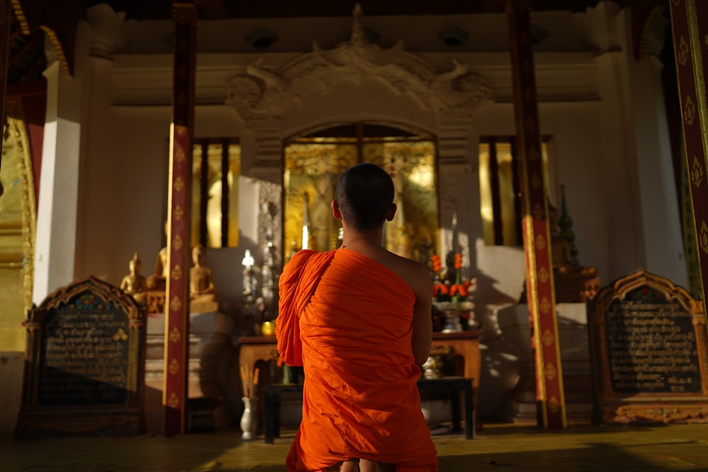 a person in an orange robe sitting in a room