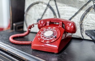a red telephone sitting on top of a table