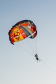 a person is parasailing in the sky with a parachute