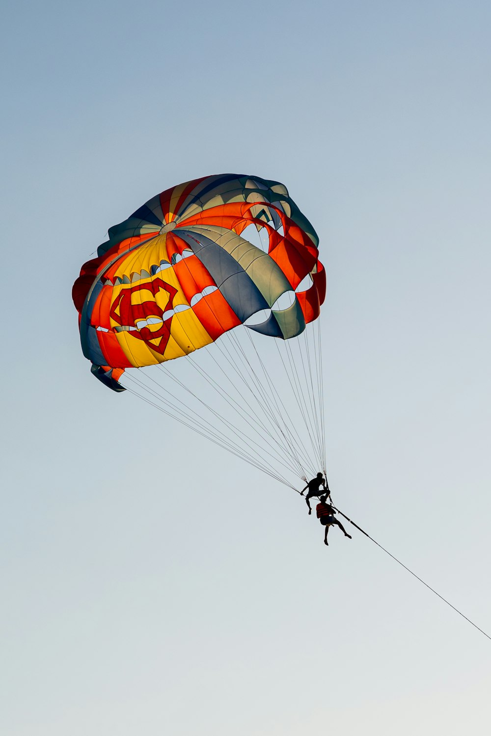 Una persona está haciendo parasailing en el cielo con un paracaídas