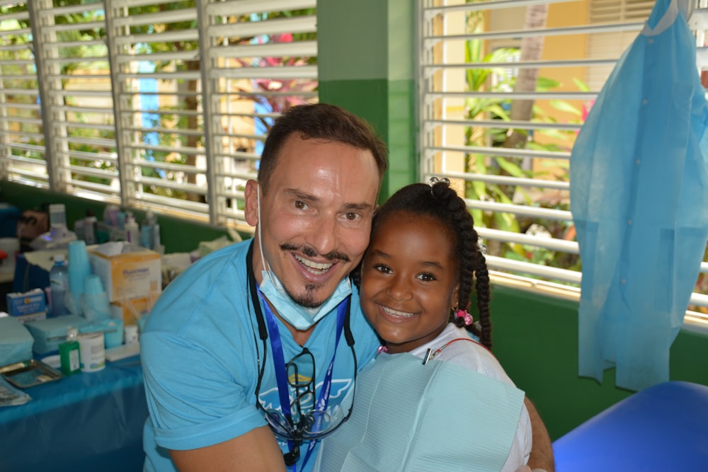 a man with a stethoscope standing next to a little girl