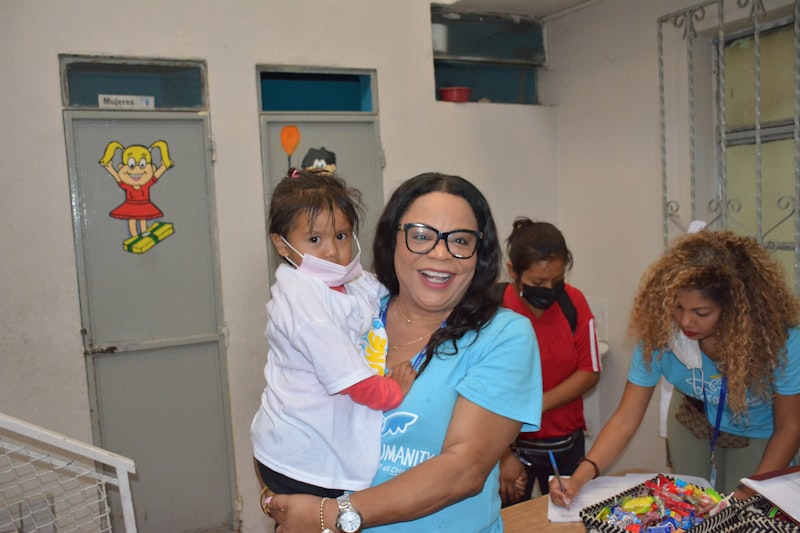 Woman holding a small child in her arms with care
