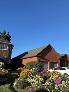 A freshly poured concrete driveway in a suburban Fulshear neighborhood under a clear blue sky.