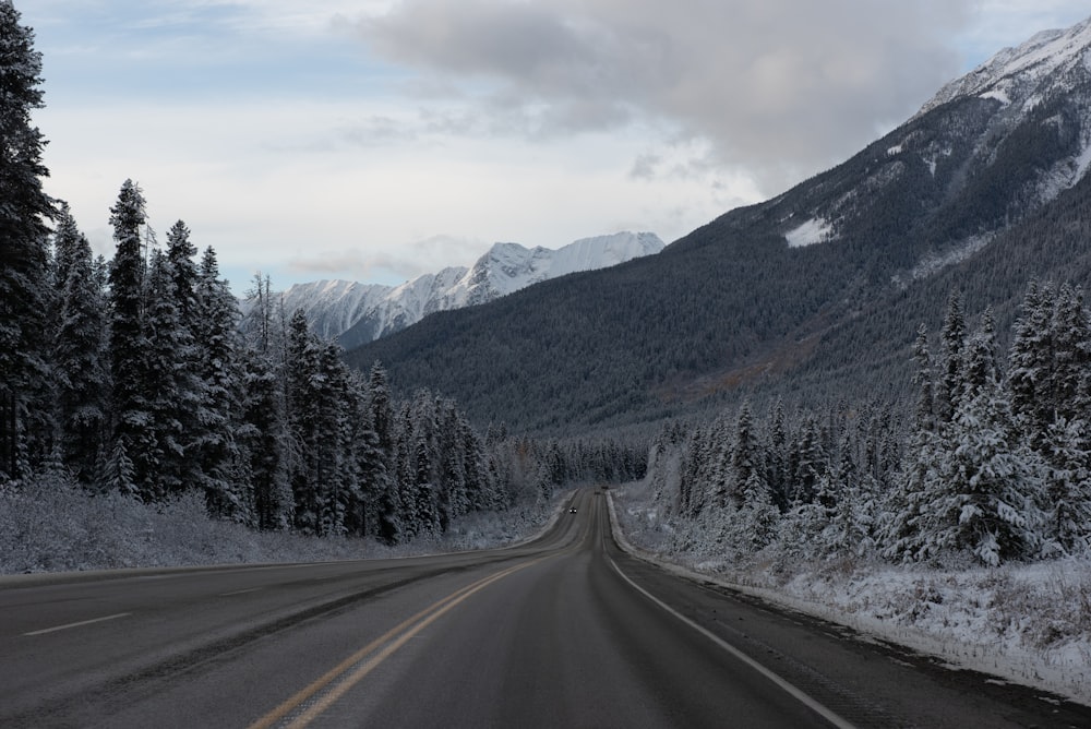 a road in the mountains with snow on the ground