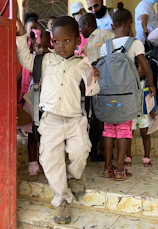 a young boy in a white shirt and tan pants
