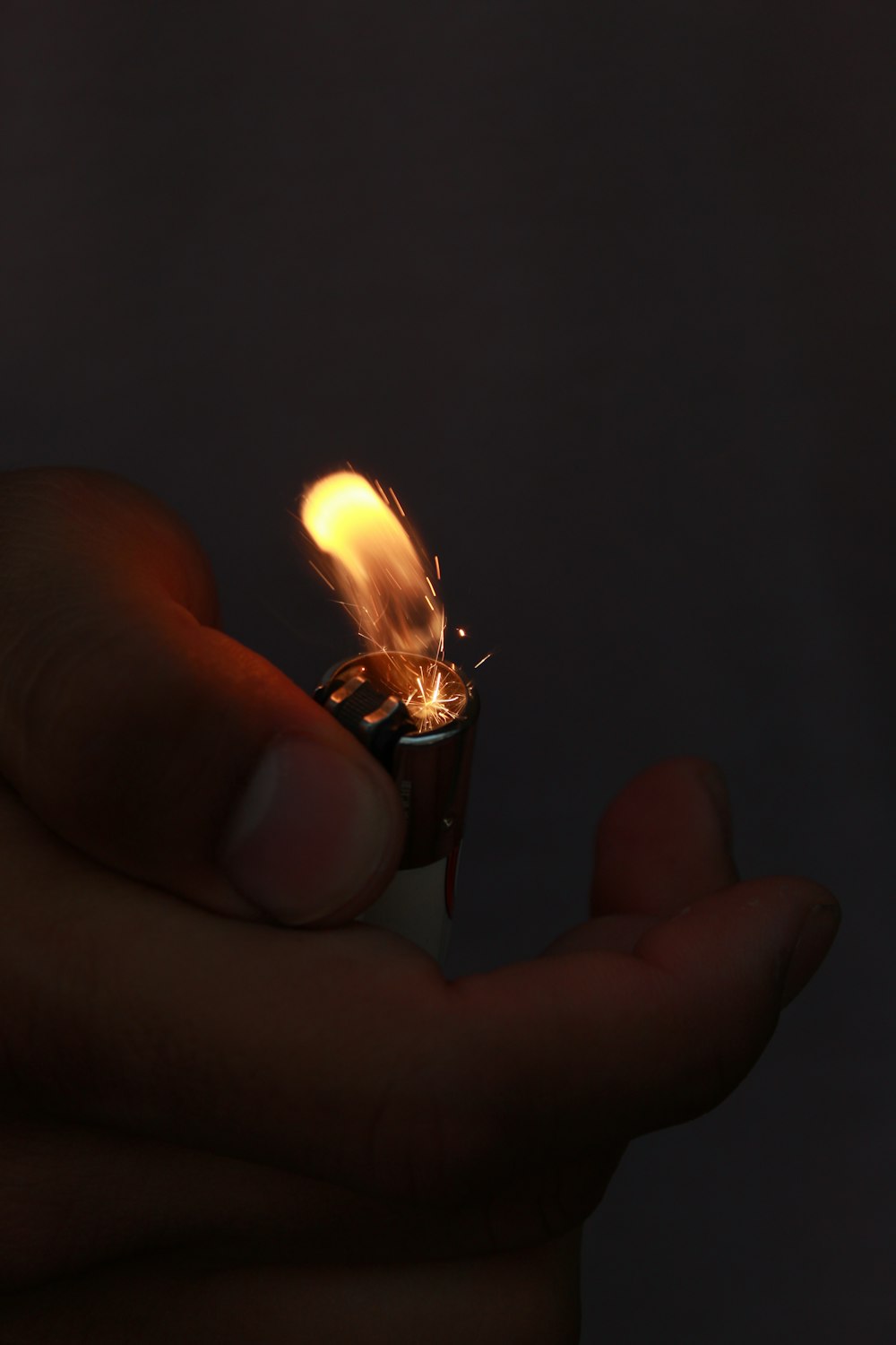 a person holding a lighter in their hand