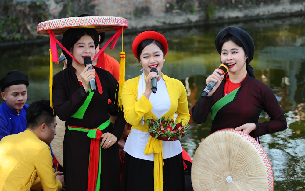 a group of women standing next to each other holding microphones