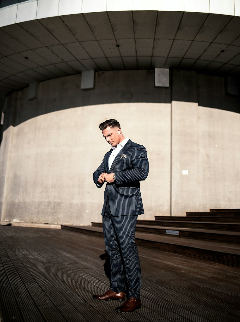 a man in a suit standing in front of a building