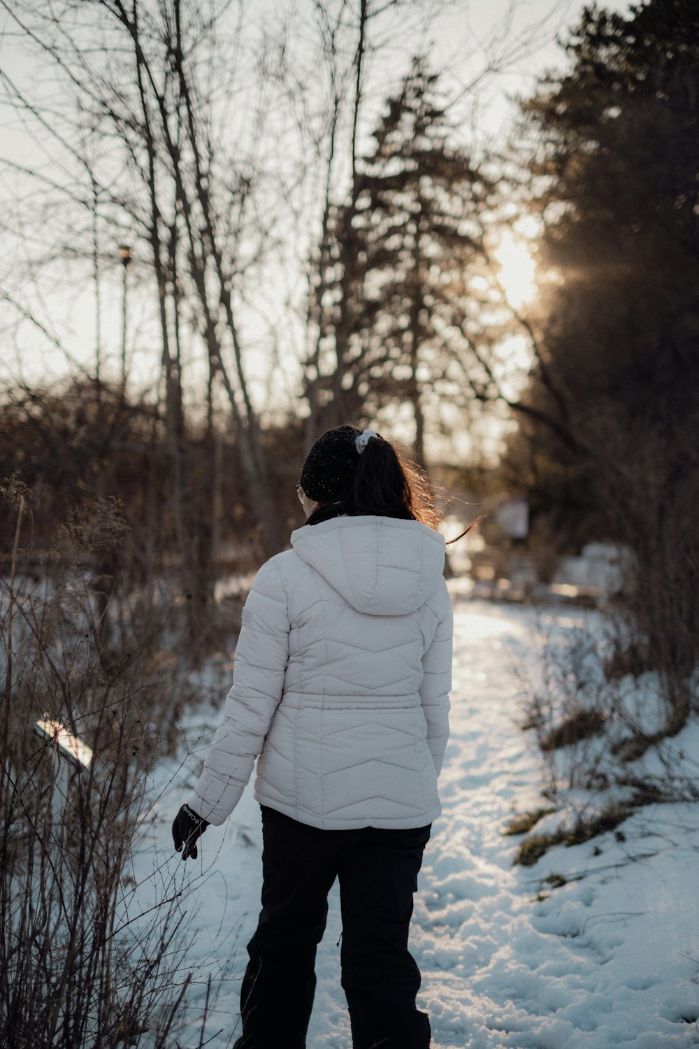 a young girl is walking through the snow