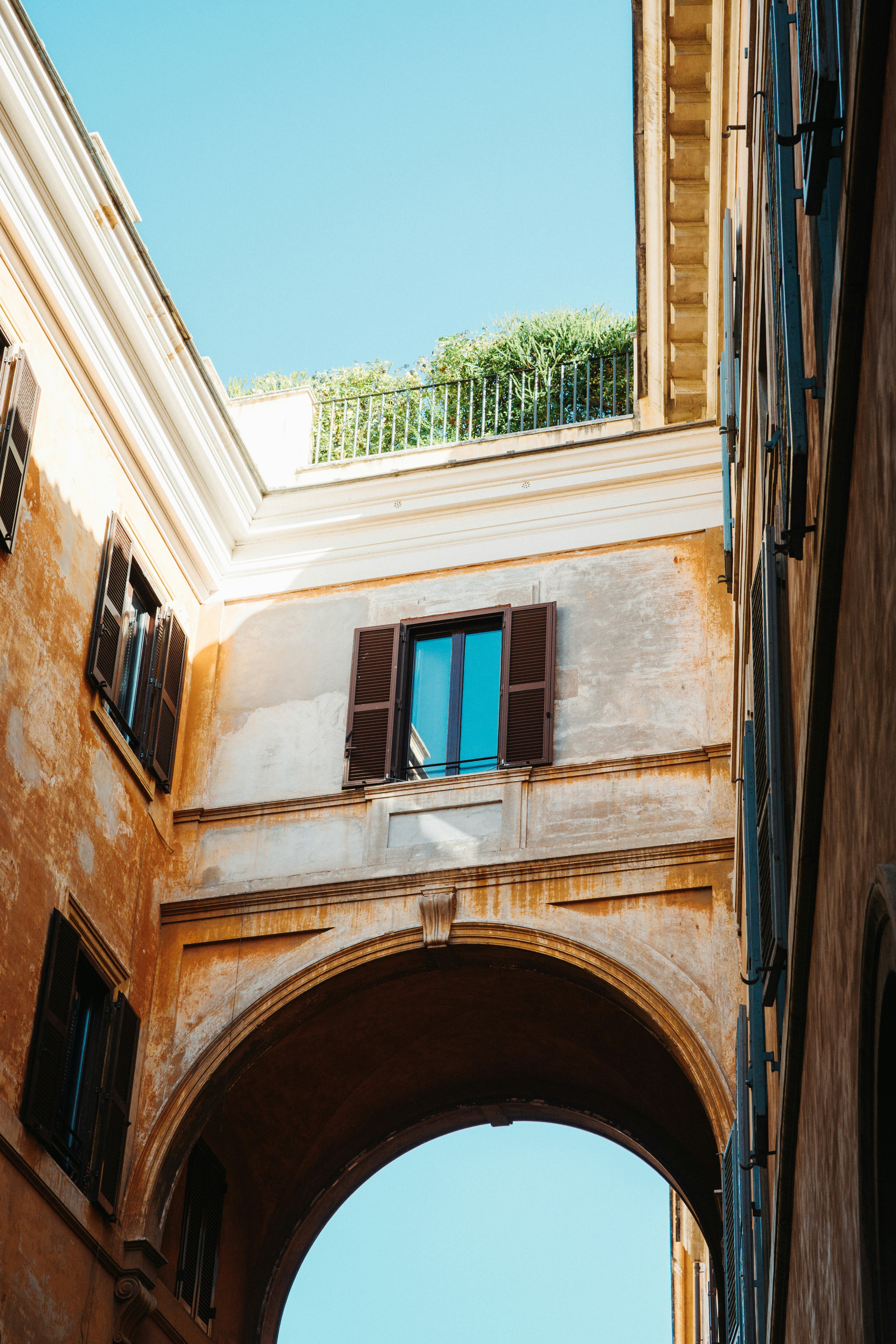 a building with an arch and a window with shutters