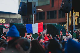 An outdoor scene of a multicultural crowd gathered for a literary event celebrating French language.