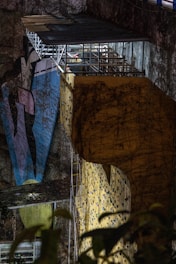Technicians inspecting a towering climbing wall under a bright sky.