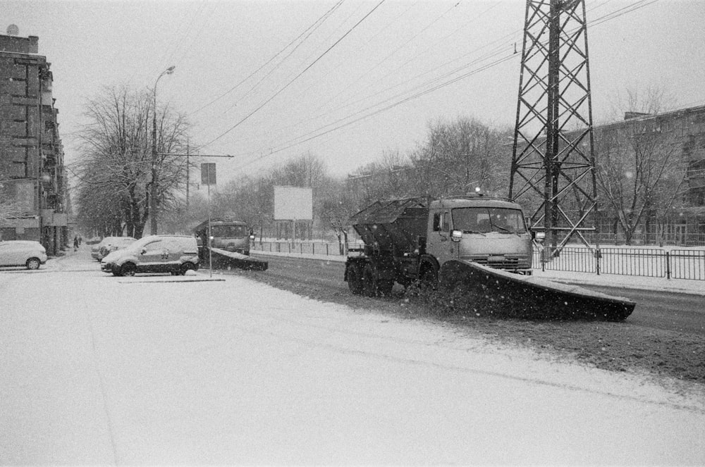 a snow plow driving down a snow covered street