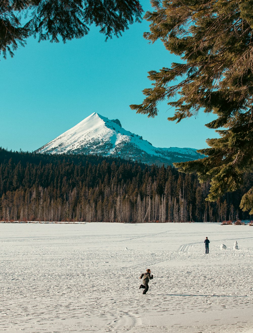 a person riding a snowboard across a snow covered field