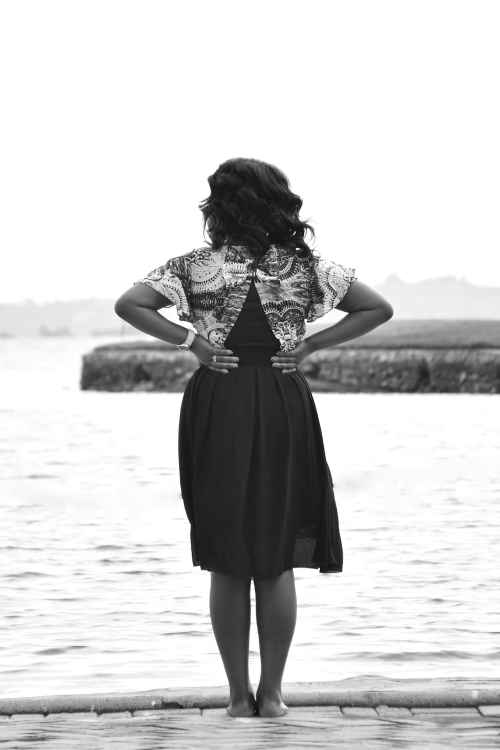 a woman standing on a dock looking at the water