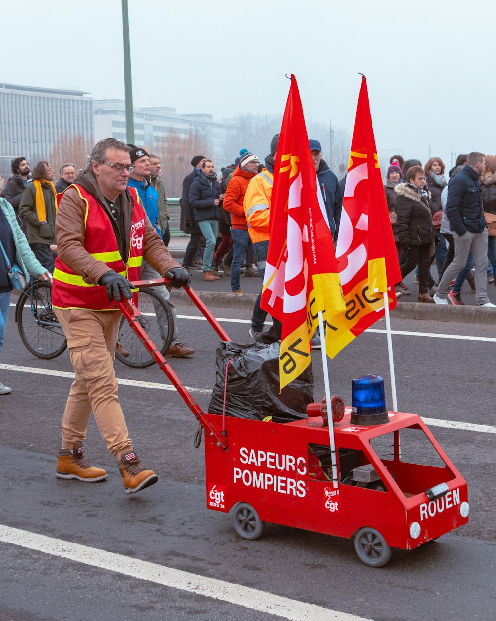 a man pushing a cart with flags on it