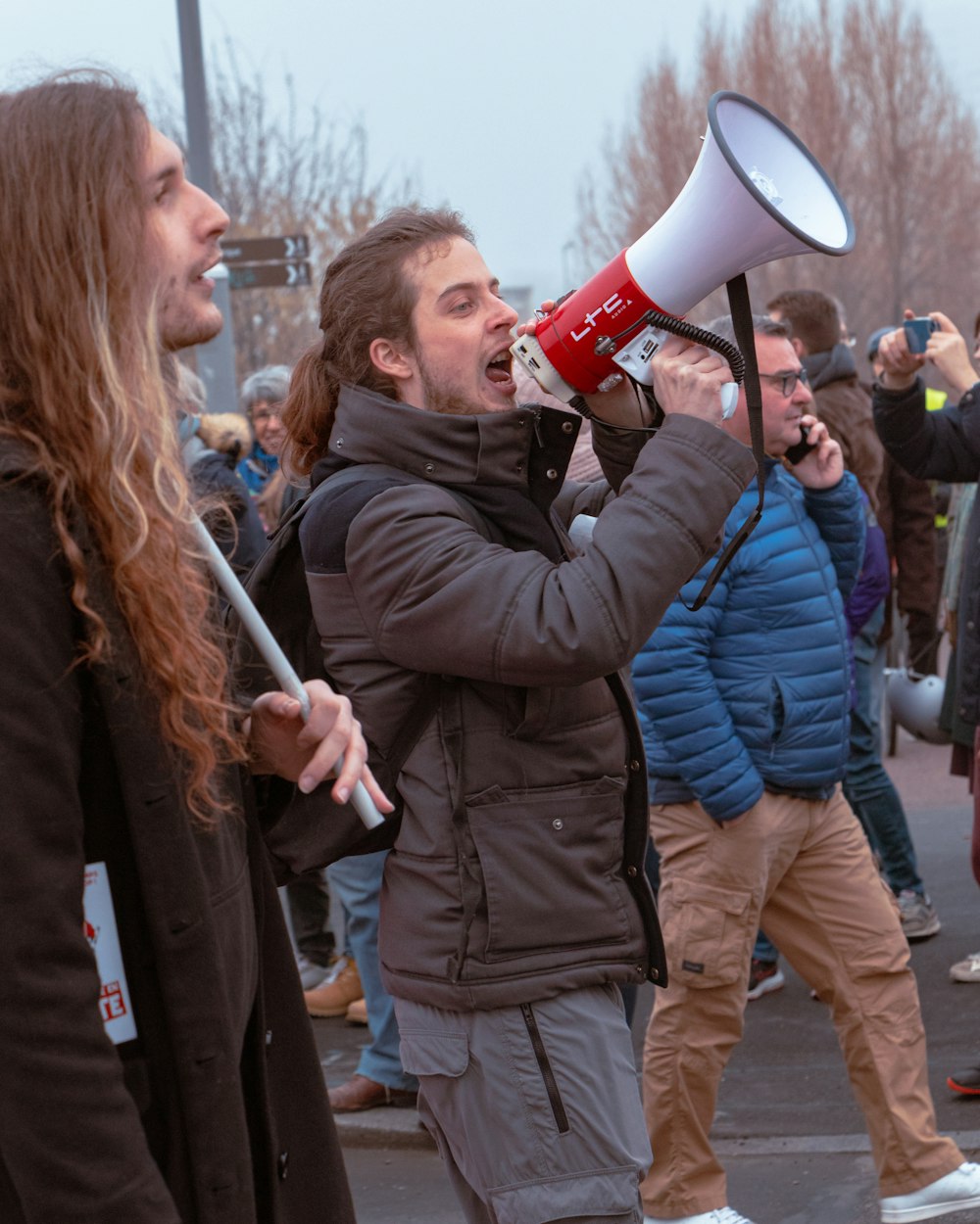 a man with long hair holding a red and white megaphone