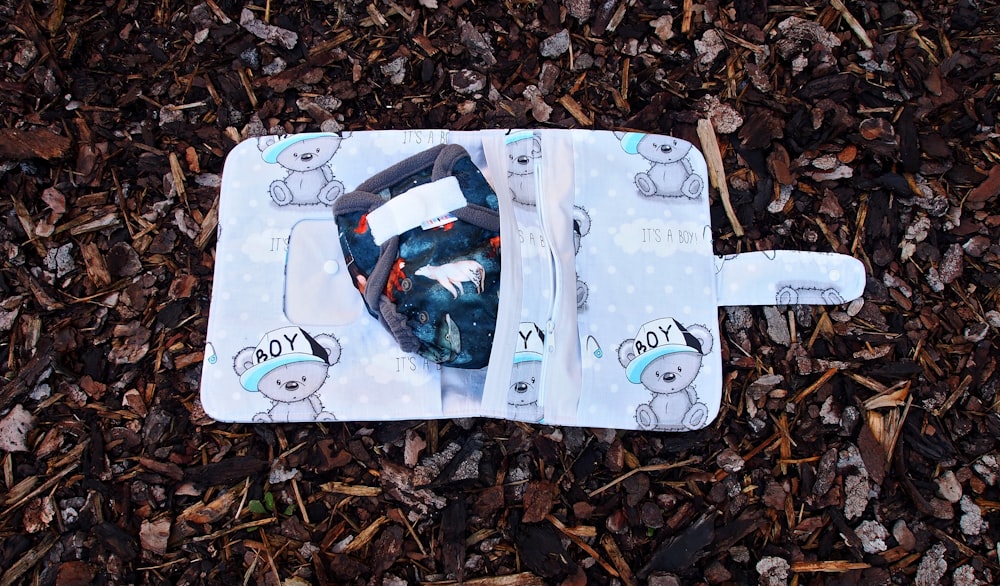 a baby bib laying on top of a pile of leaves