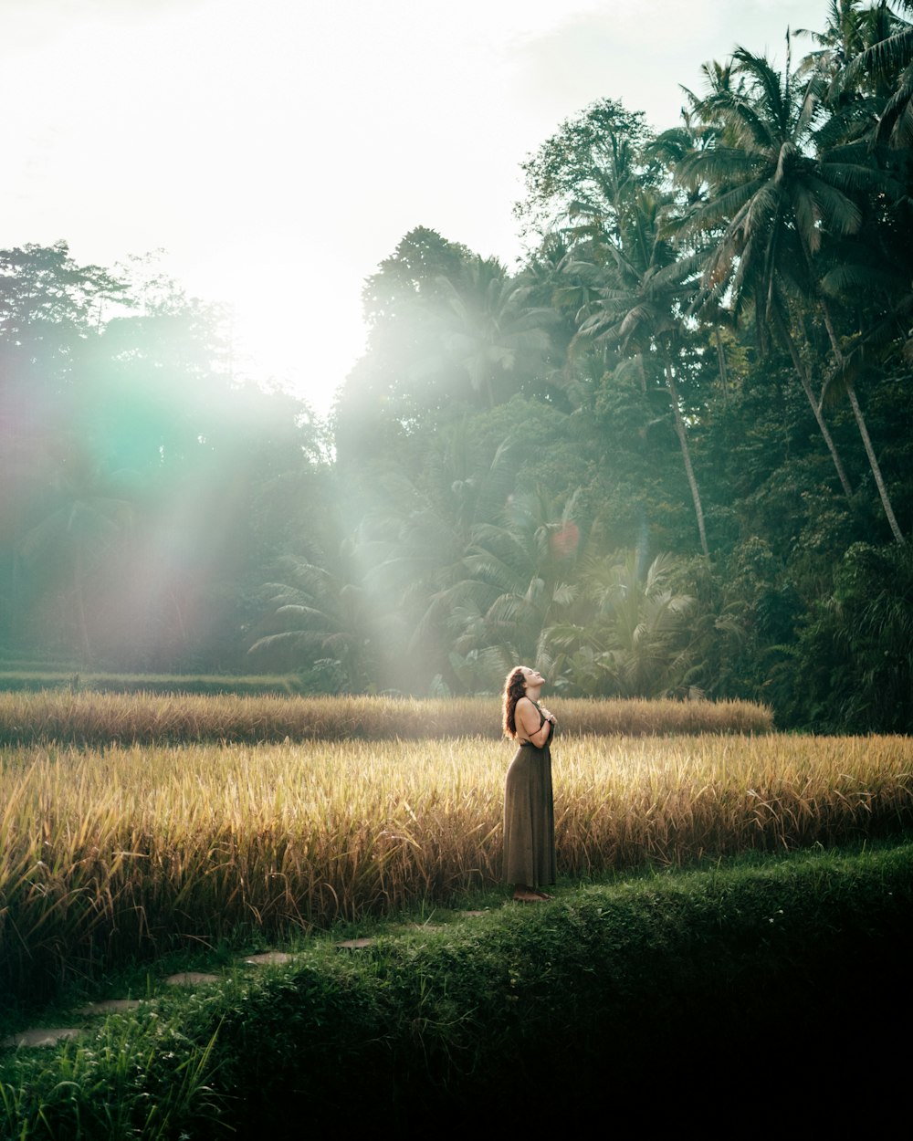 a woman standing in a field of tall grass