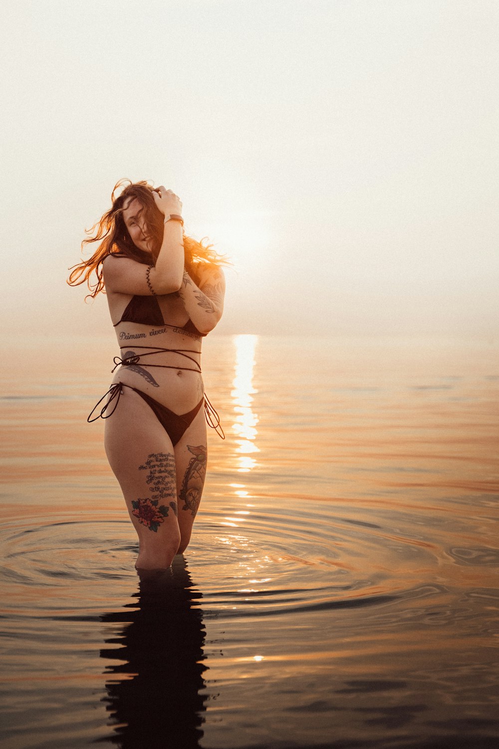 a woman in a bikini is walking in the water