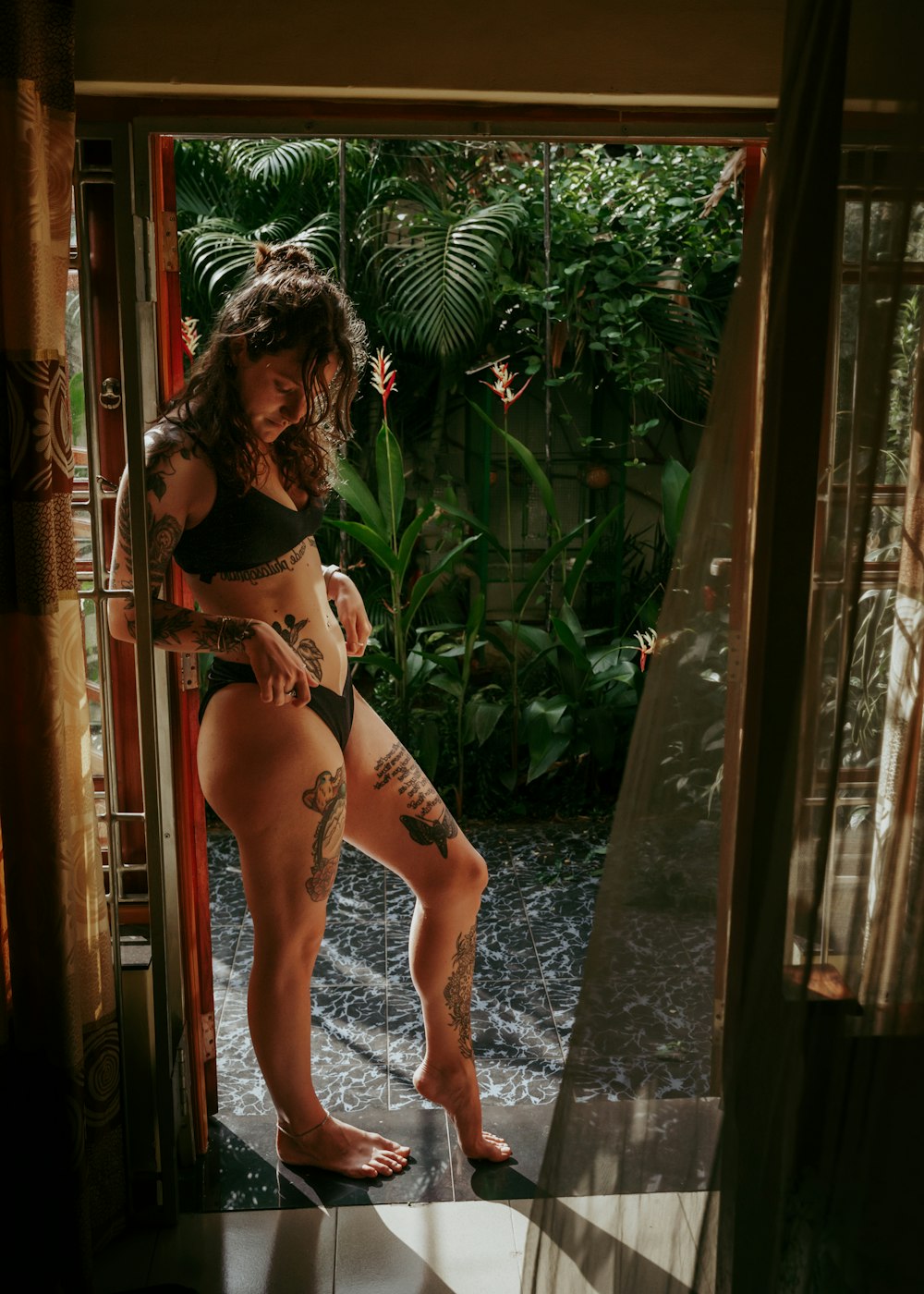 a woman in a bikini standing in a doorway